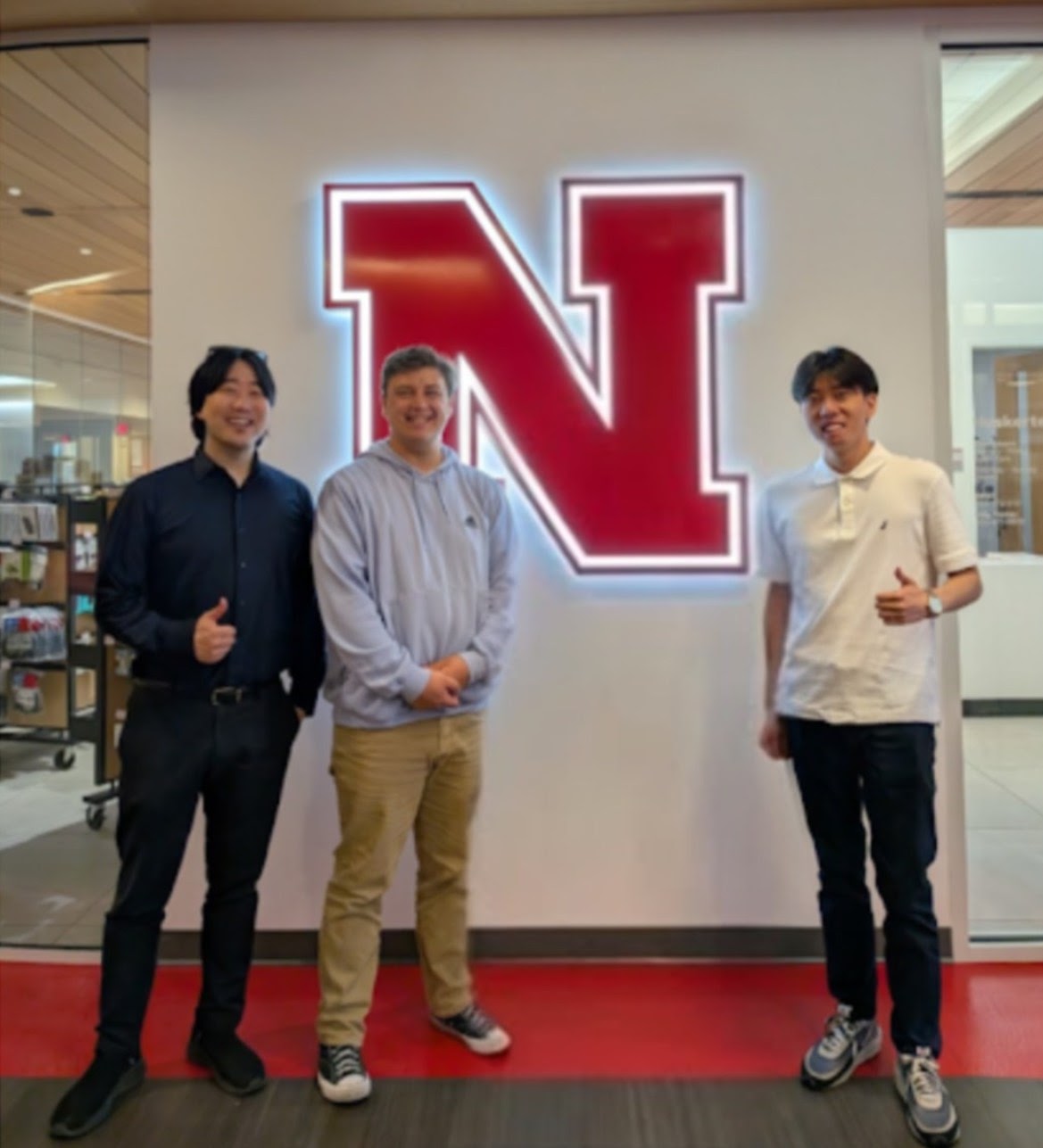 Lab members in front of the Nebraska N sign